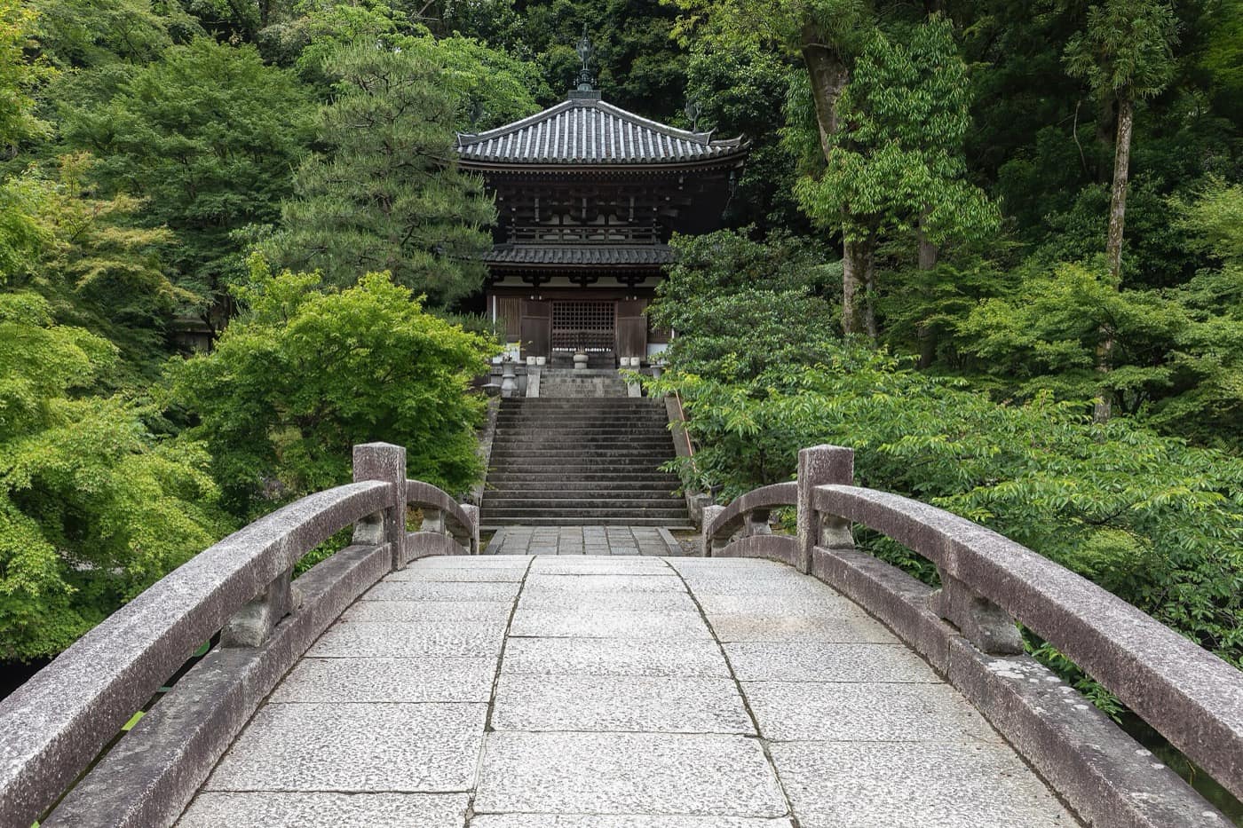 Kyoto — Stone bridge leading to a cemetery surrounded by trees in the compounds of Chion-in Kyoto Japan